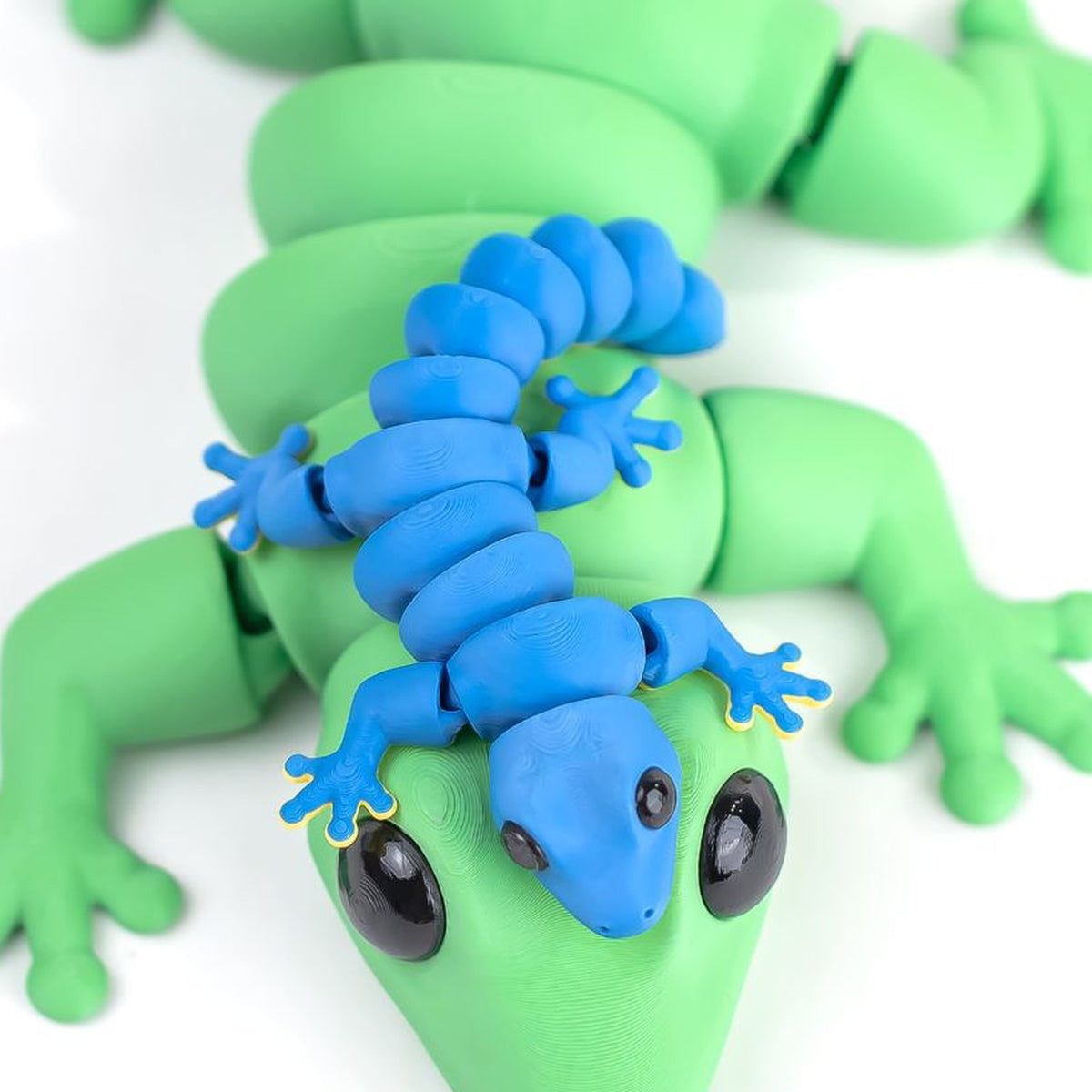 Baby Gecko — articulated 3D printed gecko figurine in green, with a smaller blue gecko