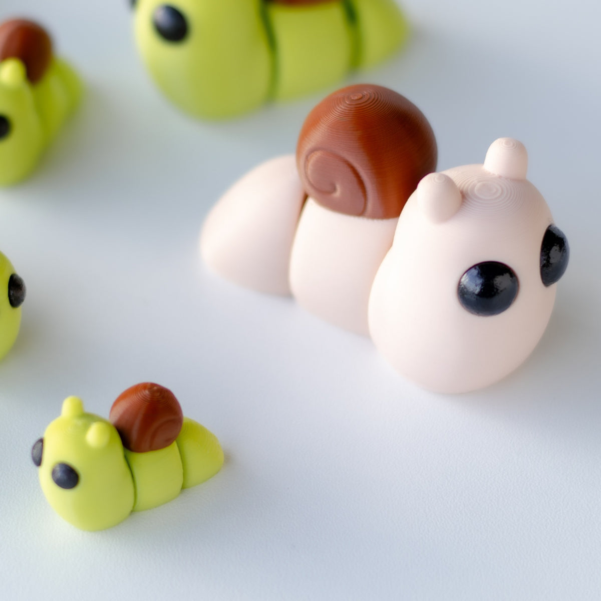 Tiny Snail — 3D printed snail figurines in green and pink with brown shells