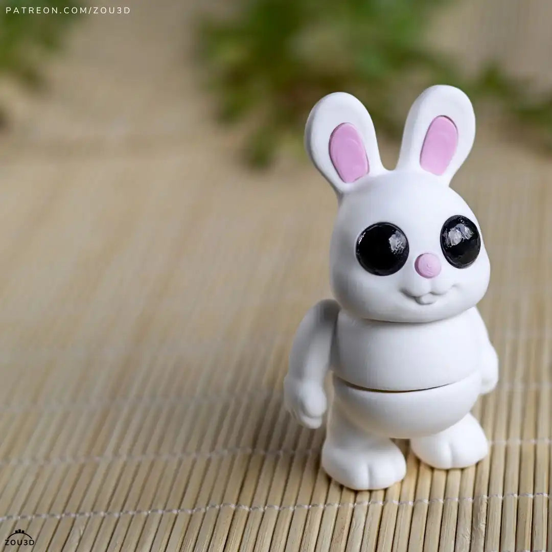 Zou3D Tiny Bunny: upright white bunny with pink ears and nose, black eyes, small arms and feet. Creator photograph.